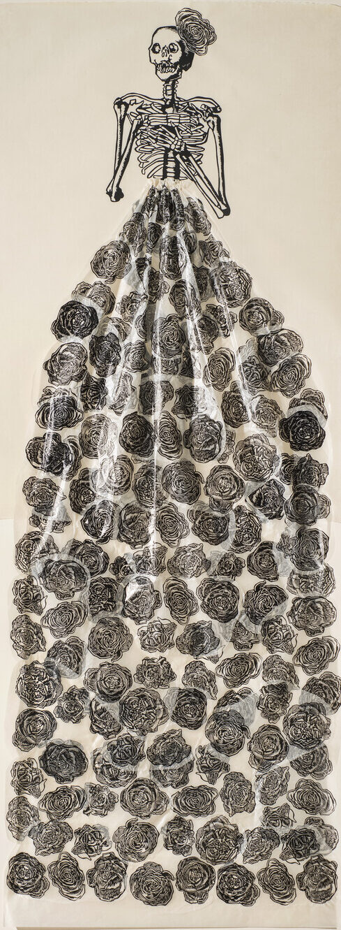 A very tall and narrow, black-and-white print depicts a skeleton with folded arms and a rose fascinator perched on its head. The figure wears a collaged, three-dimensional, billowing skirt made of tissue and printed with roses.