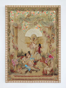 A vintage tapestry depicting three women and one man in a pastoral scene. One woman sits atop a swing while the others sit beneath her. The man holds the rope of the swing. Bright thread and beads are sewn over the original tapestry, and all four figures skin and hair have been darkened with brown and black thread.
