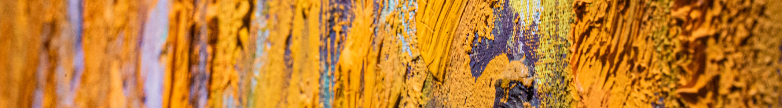 Close-up detail of an abstract painting with very thick and gestural brushstrokes of mostly orange paint.