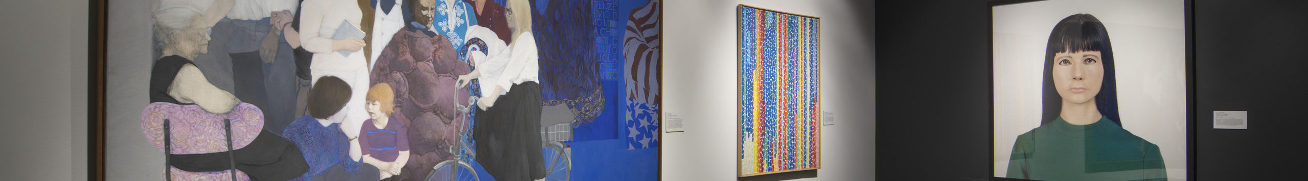 Gallery view of two large-scale, brightly colored works of art on a white wall with a wall-size portrait of a light-skinned woman on the adjacent wall.
